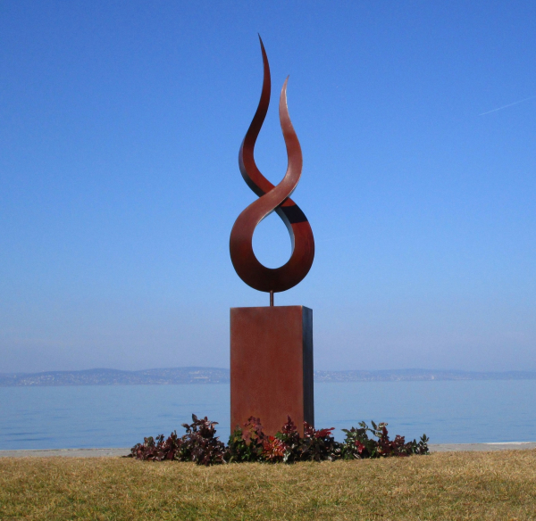 Stainless steel flame artwork on rusty column